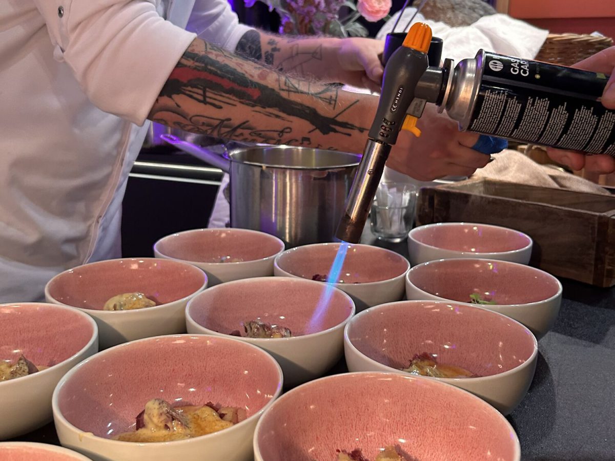 Koch flambiert Desserts in rosa Schalen bei einem Catering