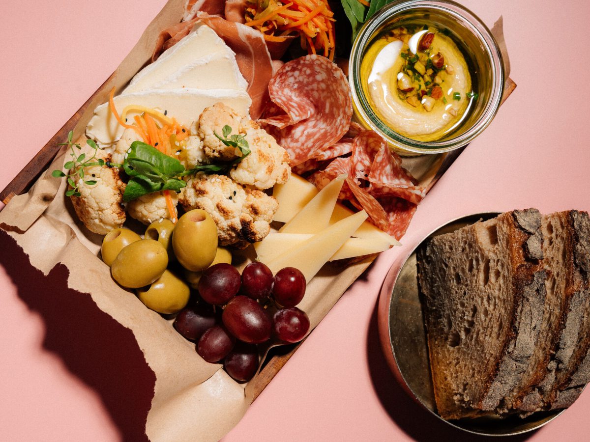 Antipasti-Brett mit Salami, Käse, Oliven und Brot von oben