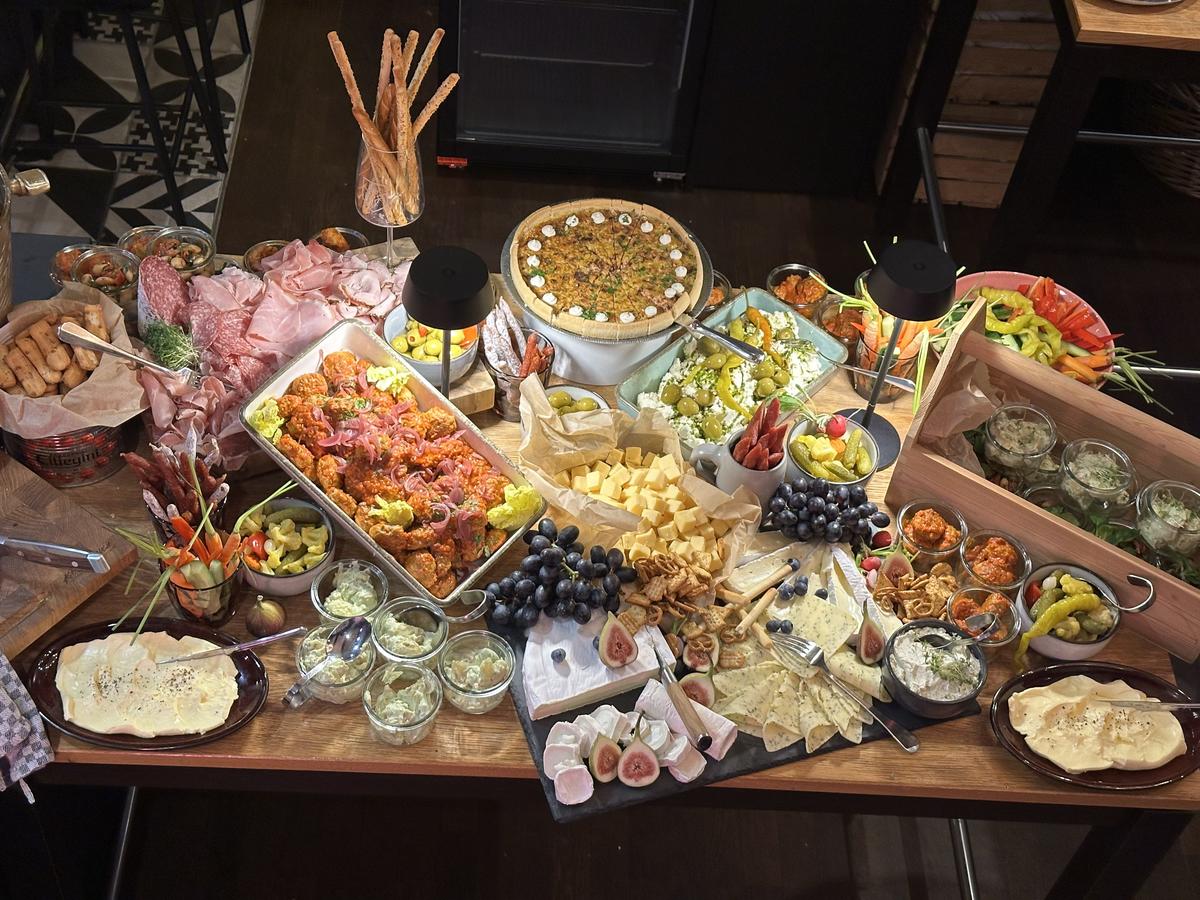 Reich gedeckter Grazing Table mit Antipasti, Käse, Fingerfood und Früchten bei einer privaten Feier
