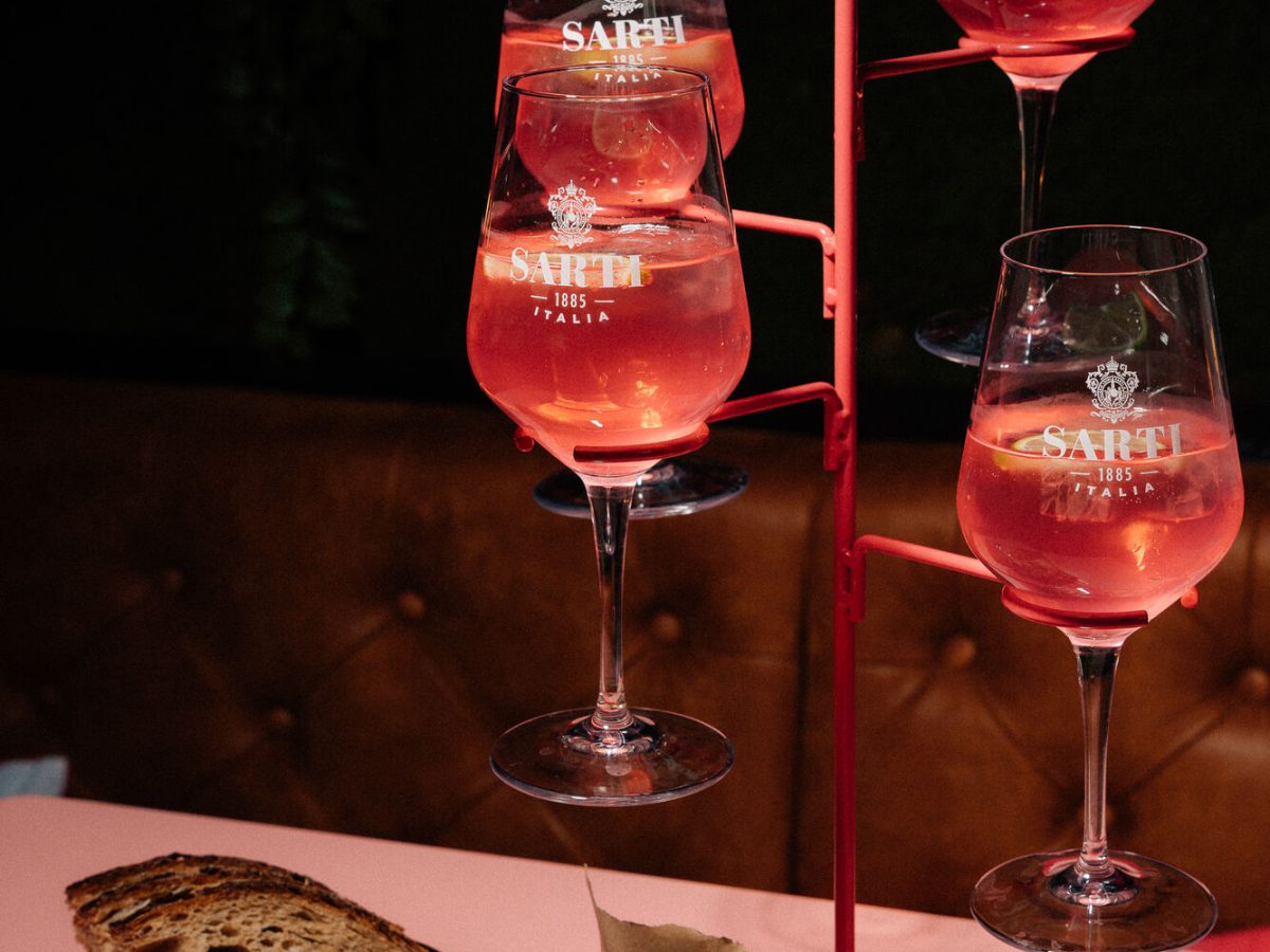 Vier Gläser SARTI Spritz auf einem roten Gläserständer