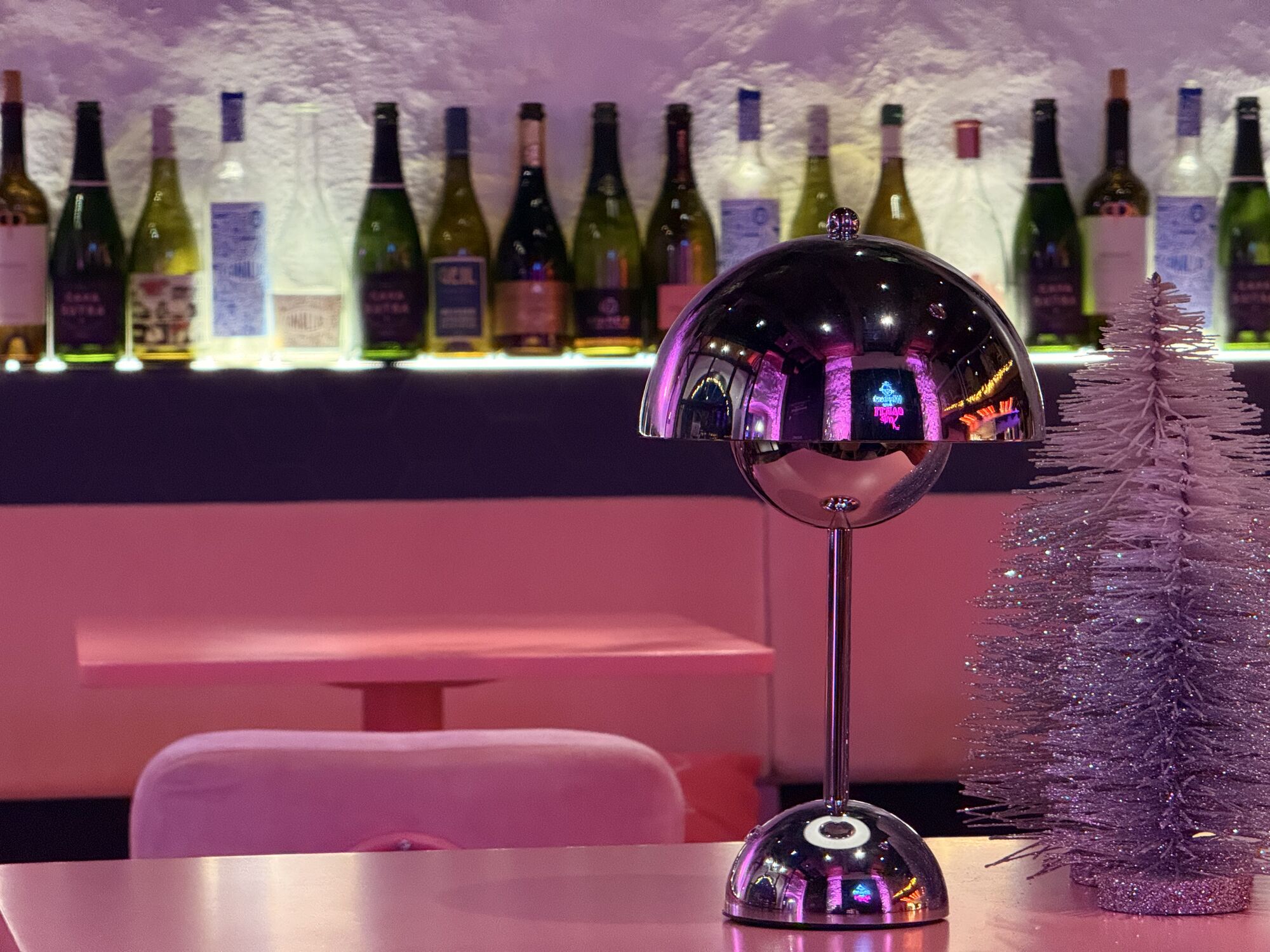 Weinregal und rosa Sitzbank in der Spritzeria mit winterlicher Deko