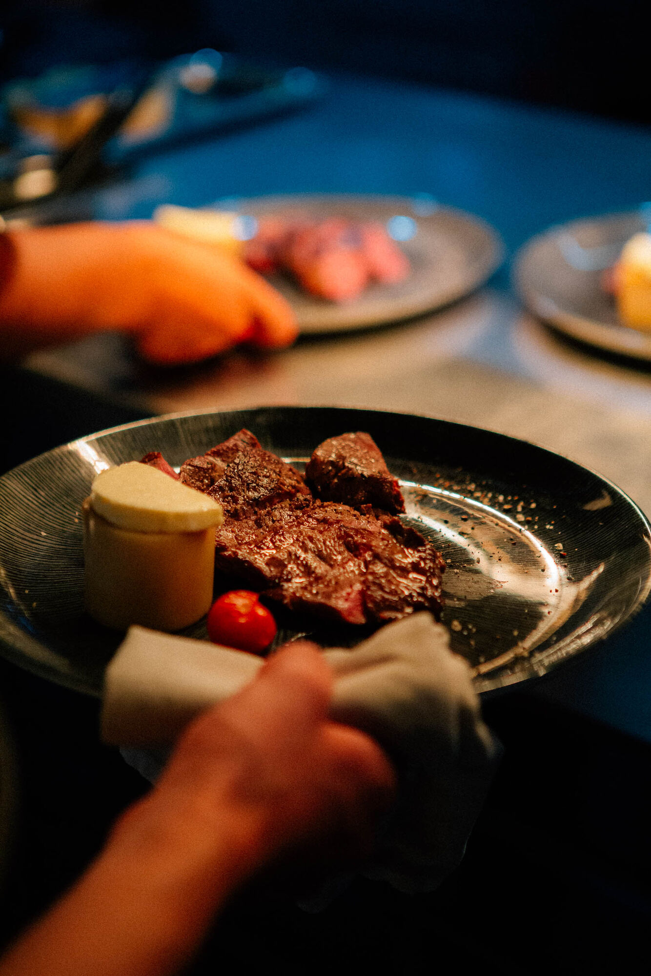 Aufgeschnittenes Steak mit Beilage auf dunklem Teller
