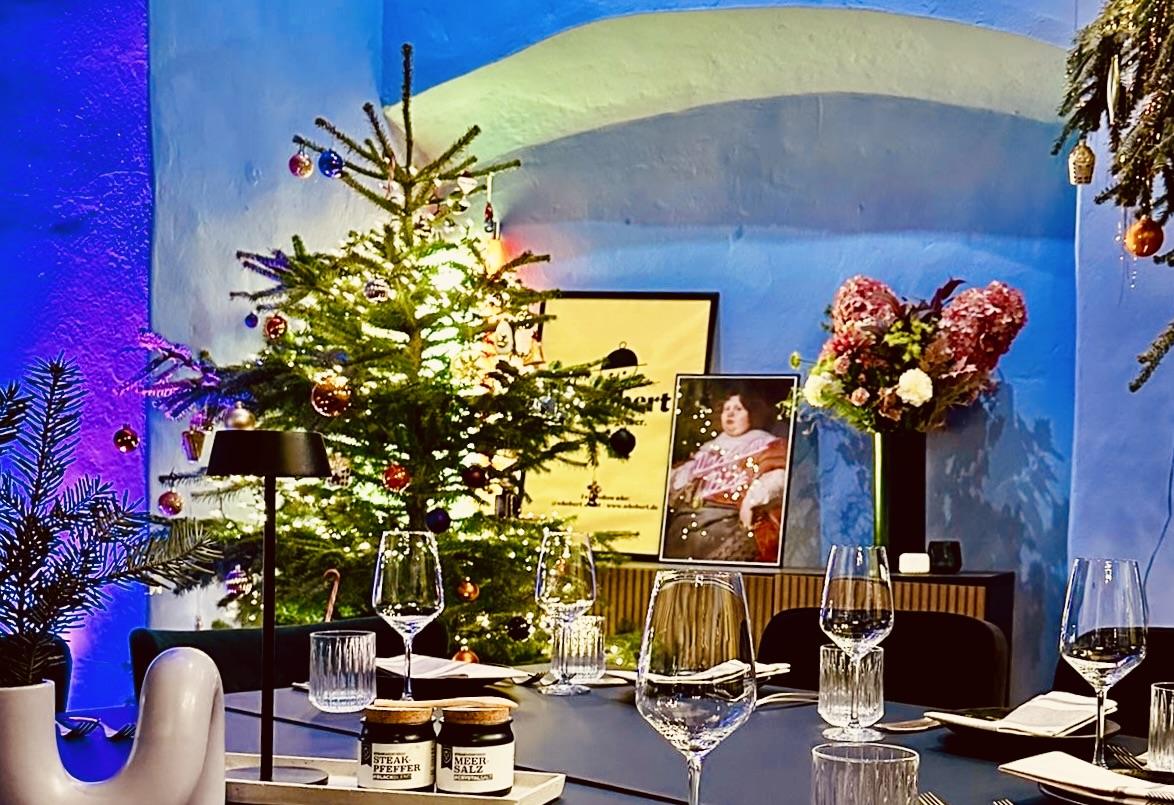 Gedeckter Tisch vor dem geschmückten Weihnachtsbaum